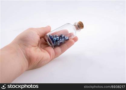 Little glass bottle with blue evil eye bead in hand