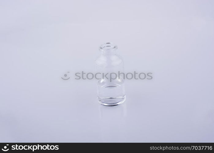 Little glass bottlewith water on a white background