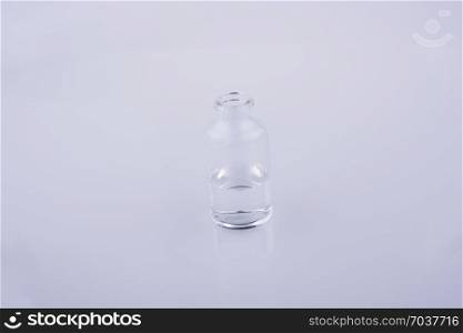 Little glass bottlewith water on a white background