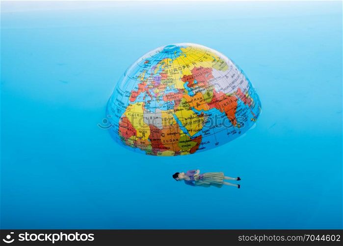 Little globe with floating figurine around in water