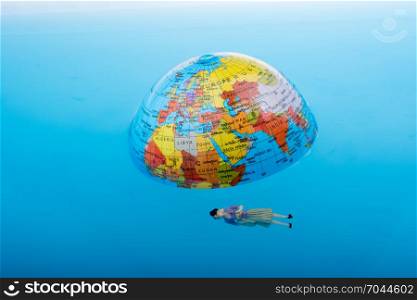 Little globe with floating figurine around in water