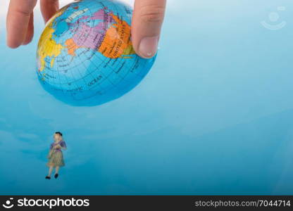 Little globe with floating figurines around in water