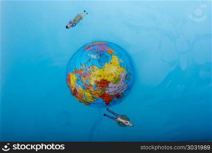 Little globe with floating figurines around. Little globe with floating figurines around in water