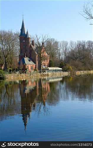 Little gothic palace on edge of Bruges Love lake. Clear spring day. Belgeum