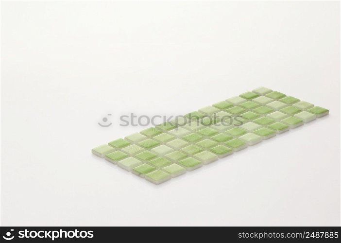 little green ceramic tile on a white background, majolica. for the catalog. square small tile