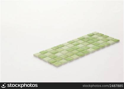 little green ceramic tile on a white background, majolica. for the catalog. square small tile