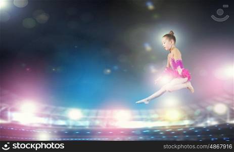 Little gymnast. Cute girl gymnast in performance costume jumping high
