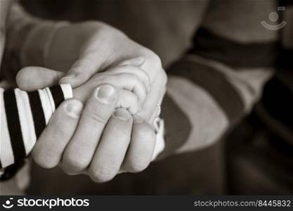 Little hand of the child in the fathers hand