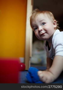 Little handsome boy playing in his room.