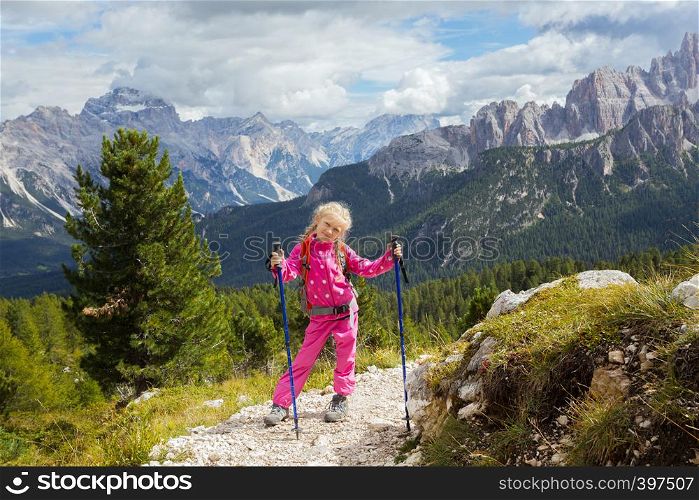 little happy girl hiker on a path at the mountains. Dolomites, Italy