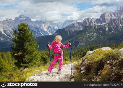 little happy girl hiker on a path at the mountains. Dolomites, Italy