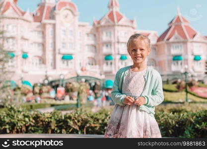 Little happy girl playing outdoors on a warm autumn day. Kids in fall. Little adorable girls at warm day in autumn park outdoors