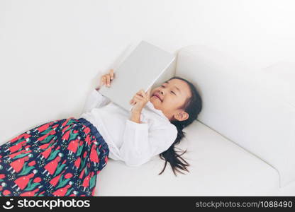 Little happy kid on white background with tablet computer. Childhood lifestyle.