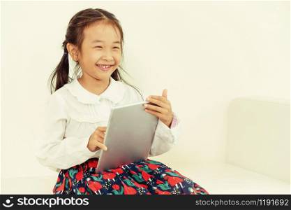 Little happy kid on white background with tablet computer. Childhood lifestyle.. Little kid on white background with tablet.