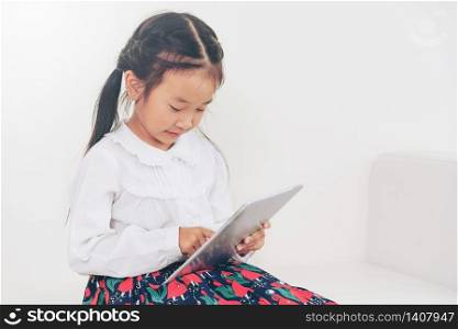 Little happy kid on white background with tablet computer. Childhood lifestyle.. Little kid on white background with tablet.