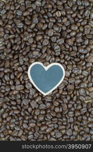 Little heart shape blackboard on coffee beans background&#xA;