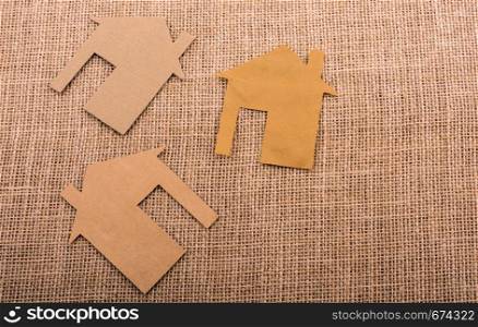 Little house shape cut out of paper on a canvas background