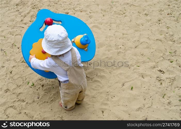Little kid playing with a wooden toy