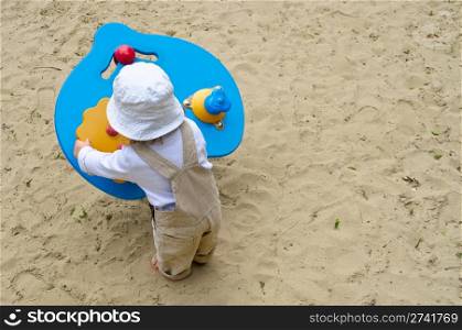 Little kid playing with a wooden toy