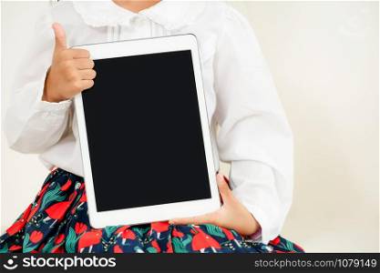 Little kid showing black screen of tablet computer on white background.