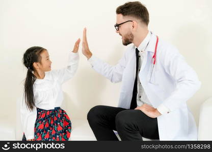 Little kid visit doctor in hospital office. The kid is happy and not afraid of the doctor. Medical and children healthcare concept.