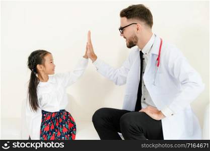 Little kid visit doctor in hospital office. The kid is happy and not afraid of the doctor. Medical and children healthcare concept.. Happy little kid visit doctor in hospital office.