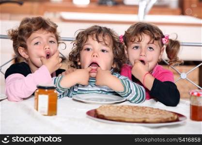 Little kids eating pancakes