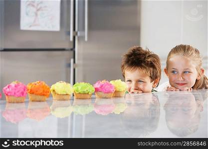 Little Kids Peeking at Cupcakes