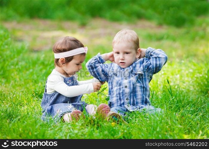 Little kids play outdoors on the grass