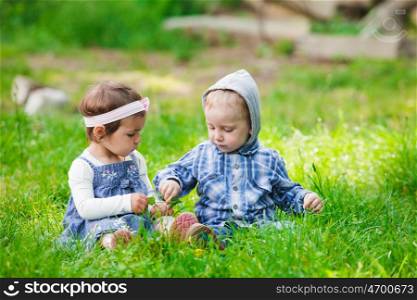 Little kids play outdoors on the grass. Children outdoor play