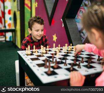 Little kids playing chess in entertainment center. Happy childhood. Adventure time. Little kids playing chess in entertainment center