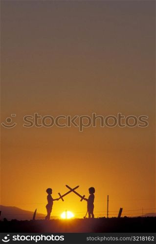 Little Kids Sword Fighting at Sunset