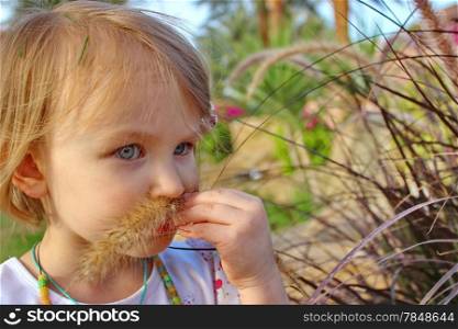 Little lady summer day mustache grass on the face