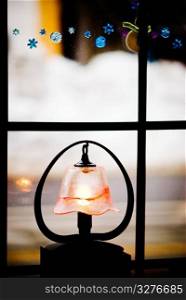 little light with glass lampshade decoration near the window