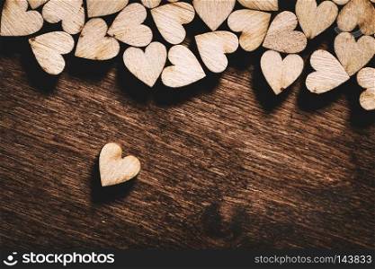 Little light wooden hearts on dark wooden background. Valentine"s Day. Love concept.. Wooden hearts on dark wooden background