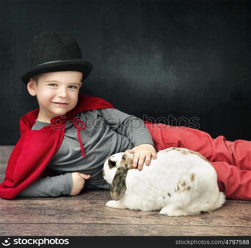Little magician boy stroking a rabbit