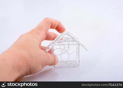 Little metal house and a hand on awhite background