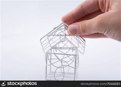 Little metal house in hand on awhite background