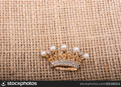 Little model crown placed on a linen canvas