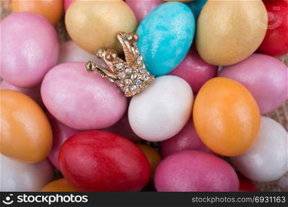 Little model crown placed on colorful candy eggs