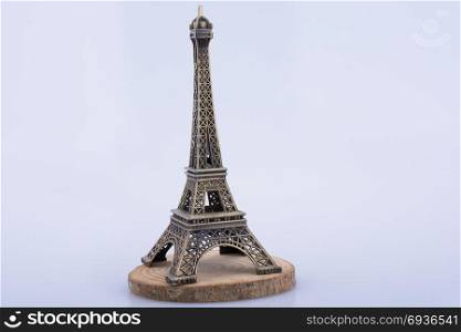 Little model Eiffel Tower on a wooden piece