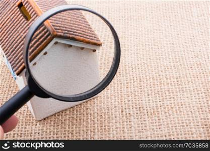 Little model house on behind a magnifying glass