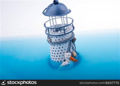 Little model lighthouse placed in blue water
