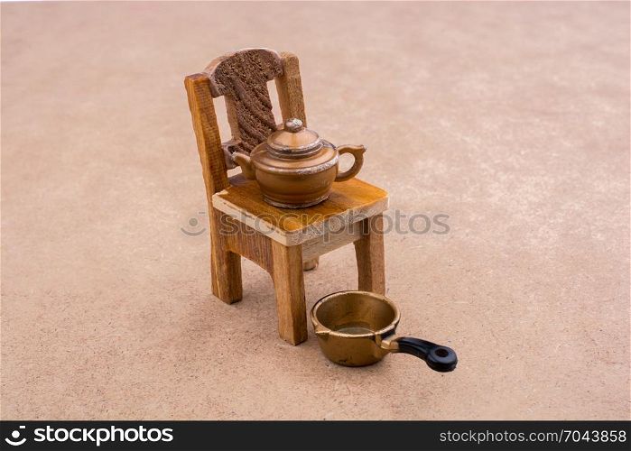 Little model pan and teapot on a model chair