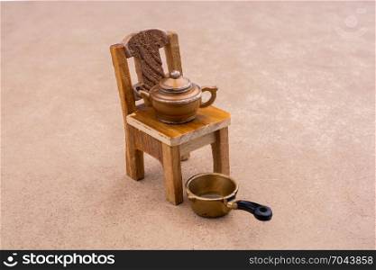 Little model pan and teapot on a model chair