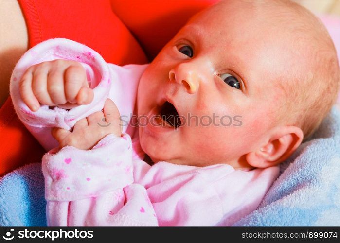 Little newborn baby in pyjamas lying on back. Face expression. Family, parenthood, childhood concept.. Family, childhood concept. Little newborn baby