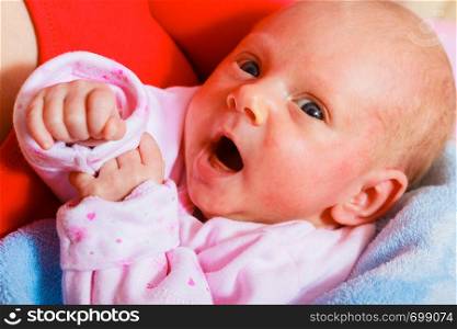 Little newborn baby in pyjamas lying on back. Face expression. Family, parenthood, childhood concept.. Family, childhood concept. Little newborn baby