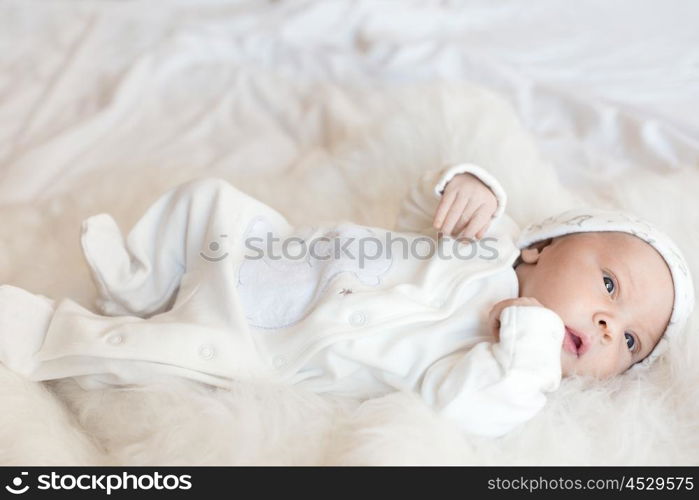 Little newborn baby over a white fur