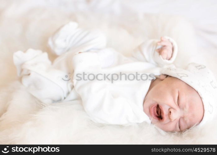 Little newborn baby over a white fur