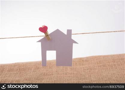 Little paper house attached to a string with a heart clip